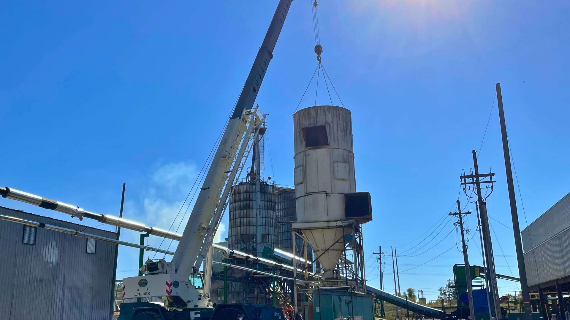 a large crane is lifting a concrete tower in a factory .