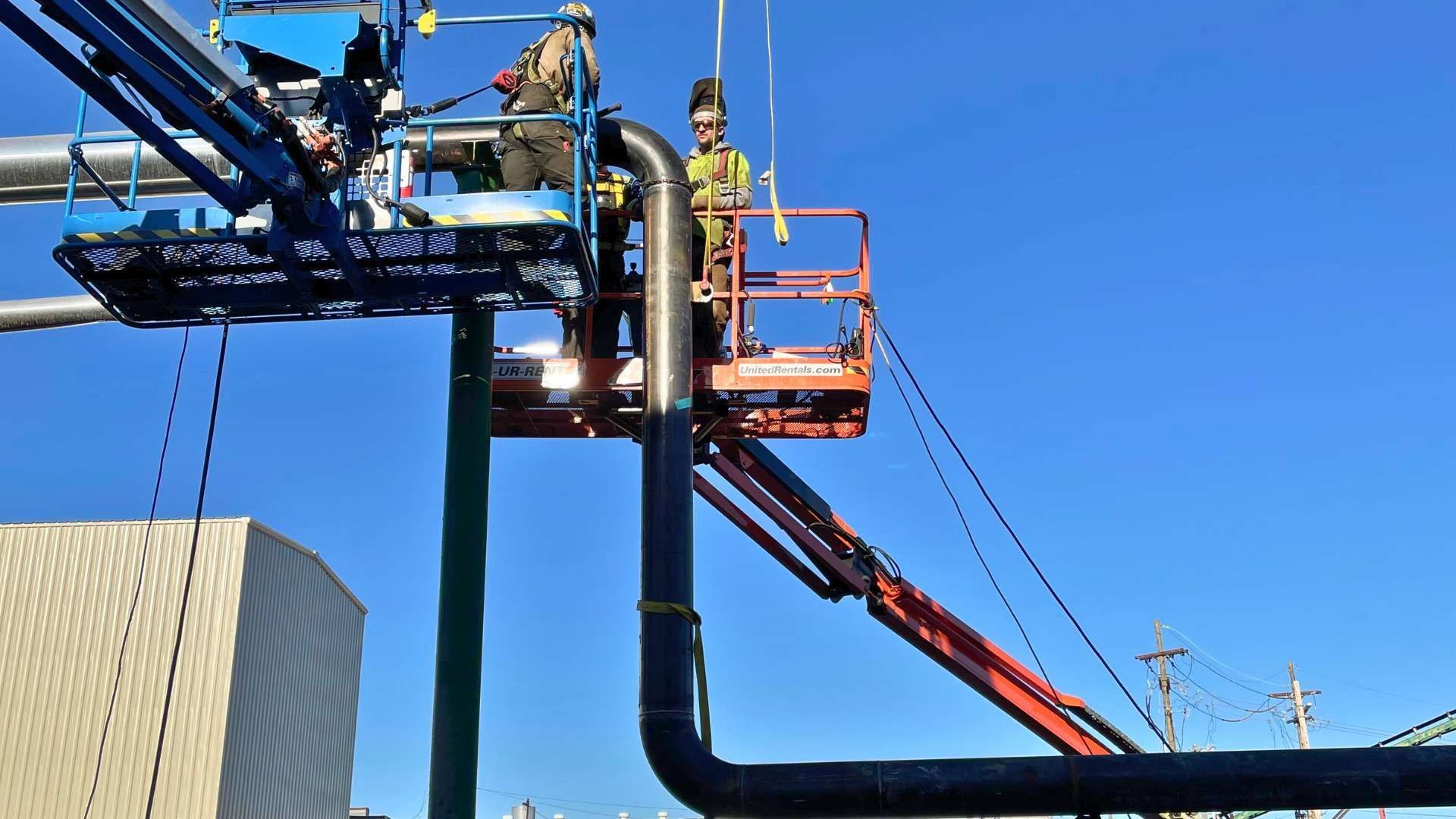 a man is working on a pipe on a crane .