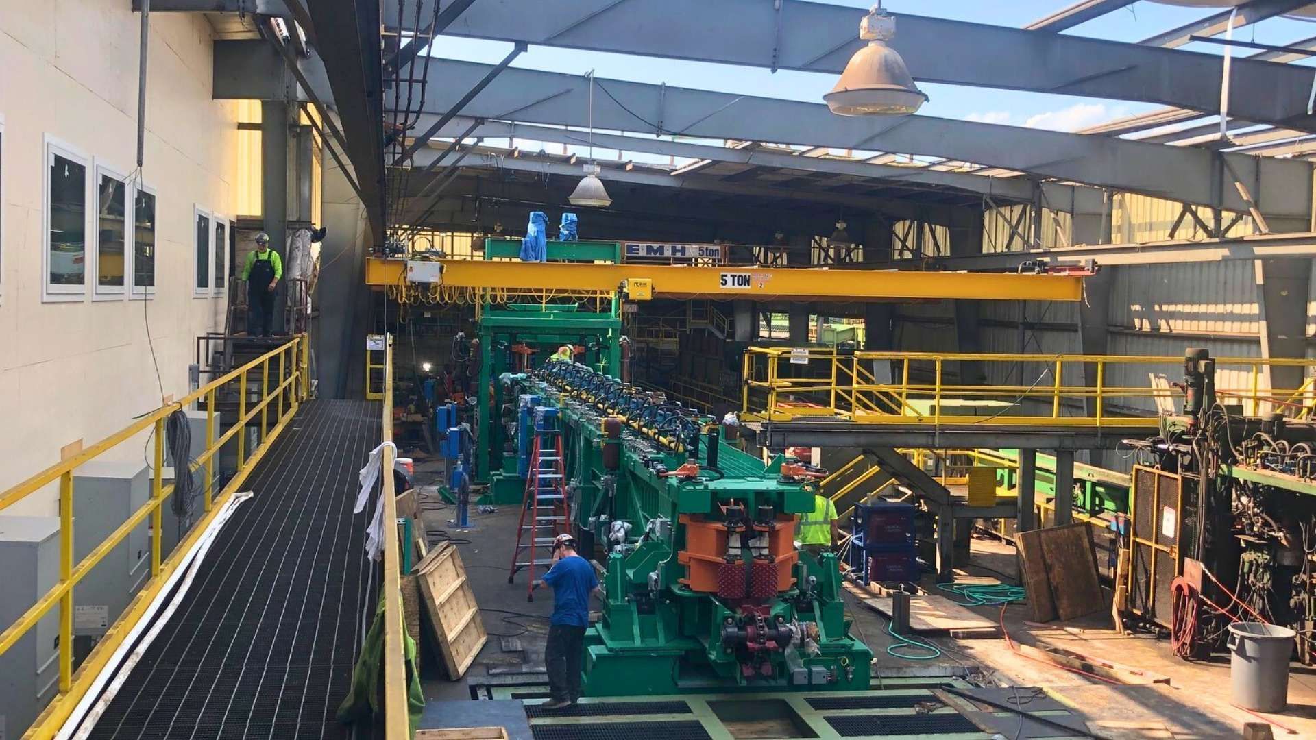 a factory with a lot of machinery and people working in it .
