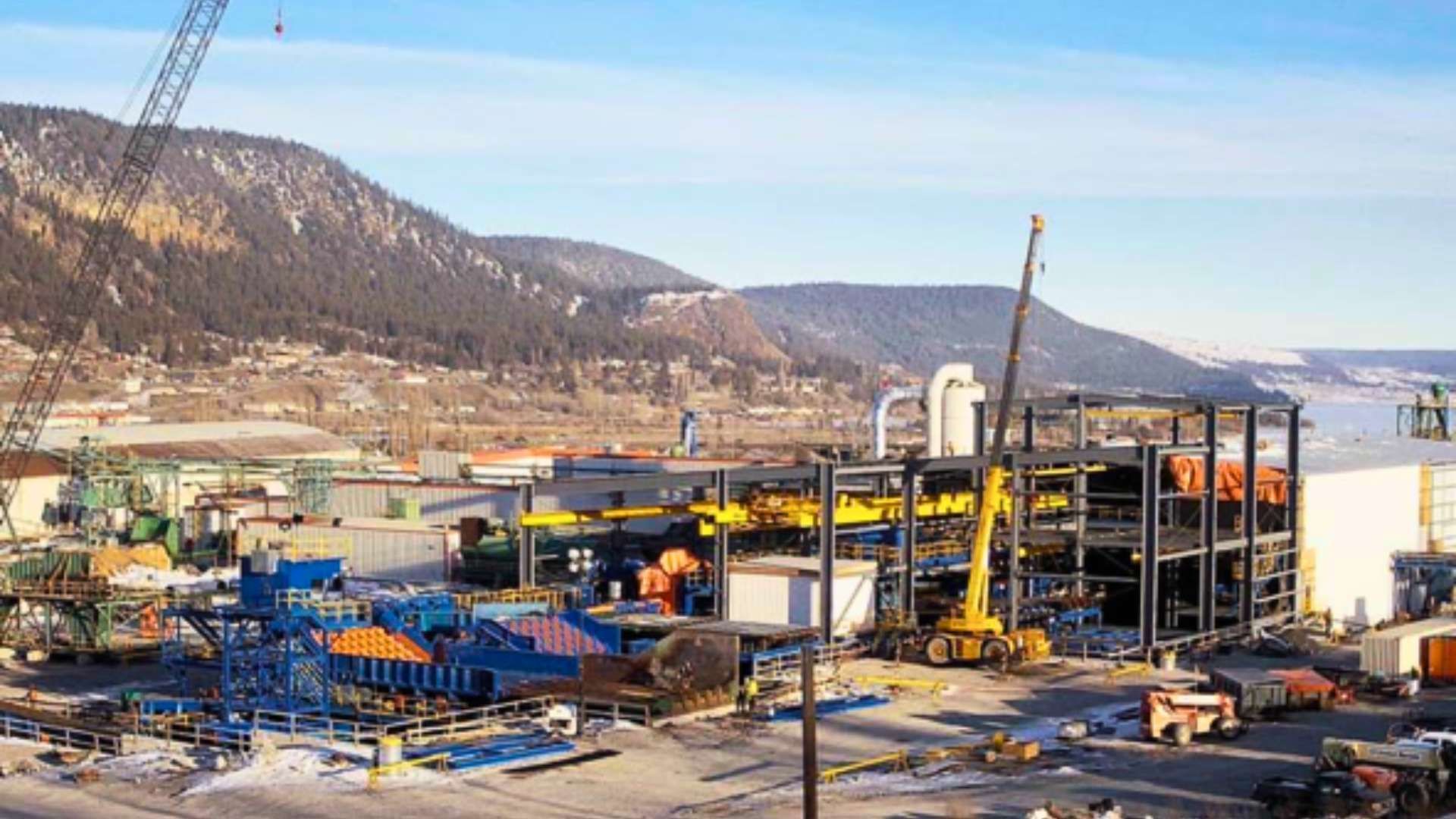 a large building is being built in a city with mountains in the background .