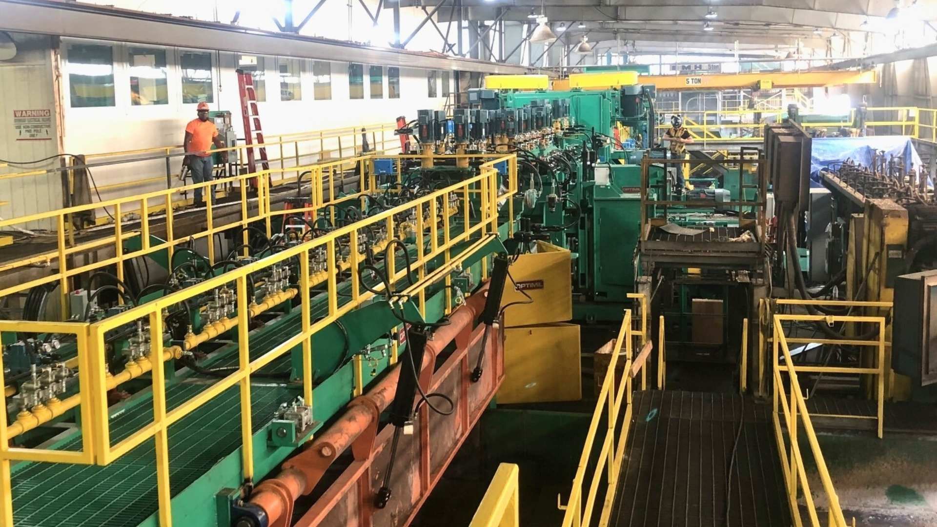 a factory with a lot of machinery and a yellow railing .