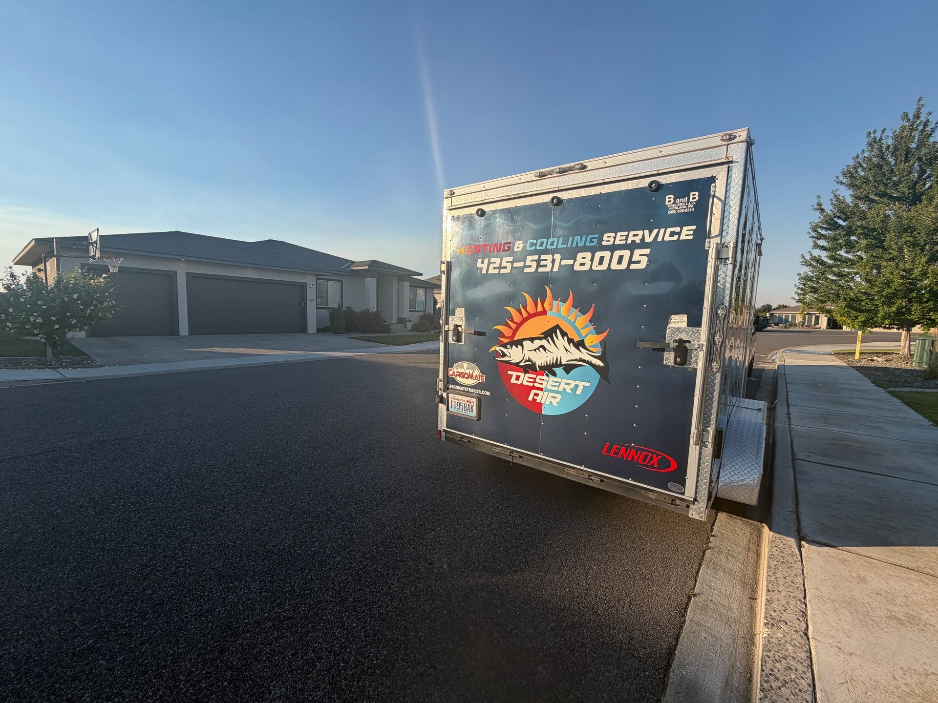 Utility trailer parked on a residential street at sunset with a house and trees in the background