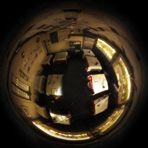 Vista in miniatura di una stanza con letti, scrivanie e finestre luminose lungo il bordo circolare.