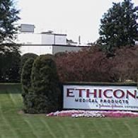 A sign for Ethicon Medical Products, a Johnson & Johnson company, situated on a lawn with trees and a building behind.