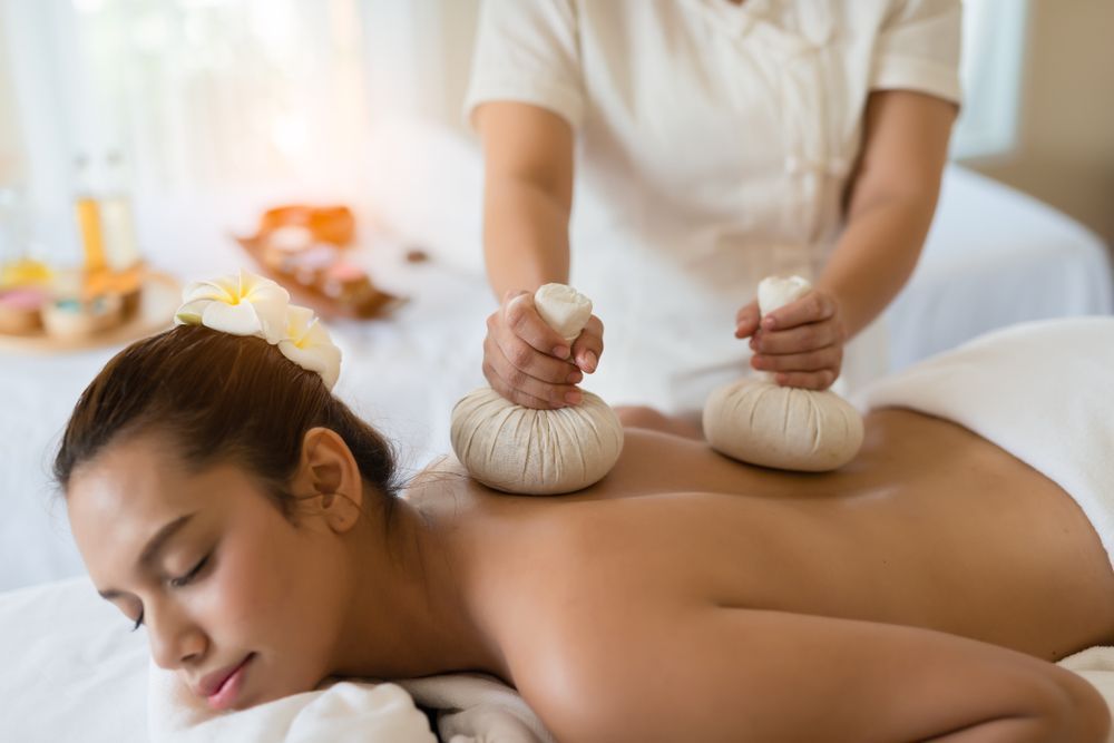 Woman Receiving Back Massage With Herbal Compress at Spa — Sage Spa & Beauty in Mackay, QLD
