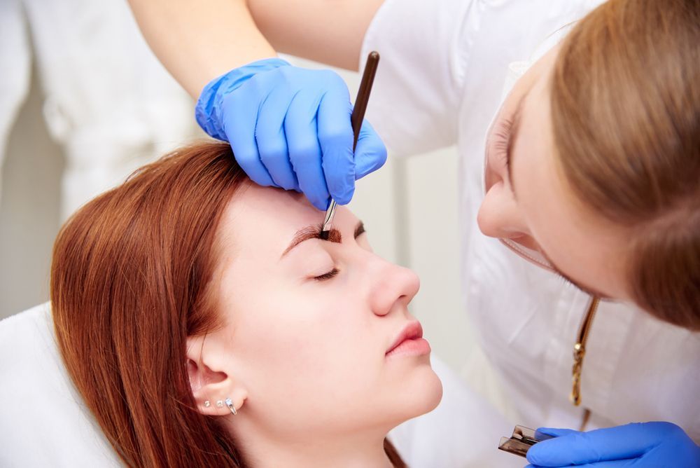 Woman Getting Eyebrow Shaping; Stylist Wearing Gloves Uses a Tool to Shape Brow — Sage Spa & Beauty in Mackay, QLD