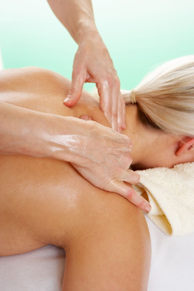 Woman Receiving Shoulder Massage, Hands Applying Pressure, on a White Towel — Sage Spa & Beauty in Mackay, QLD