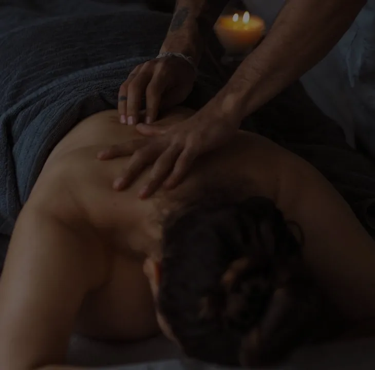 Hands Massaging a Person's Back, Lit by Candlelight — Sage Spa & Beauty in Mackay, QLD