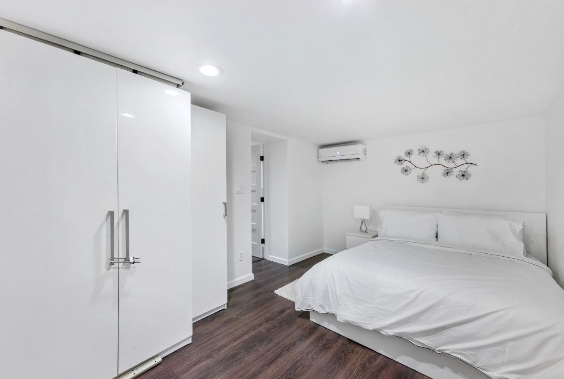 A bedroom with a bed , closets and a clock on the wall.