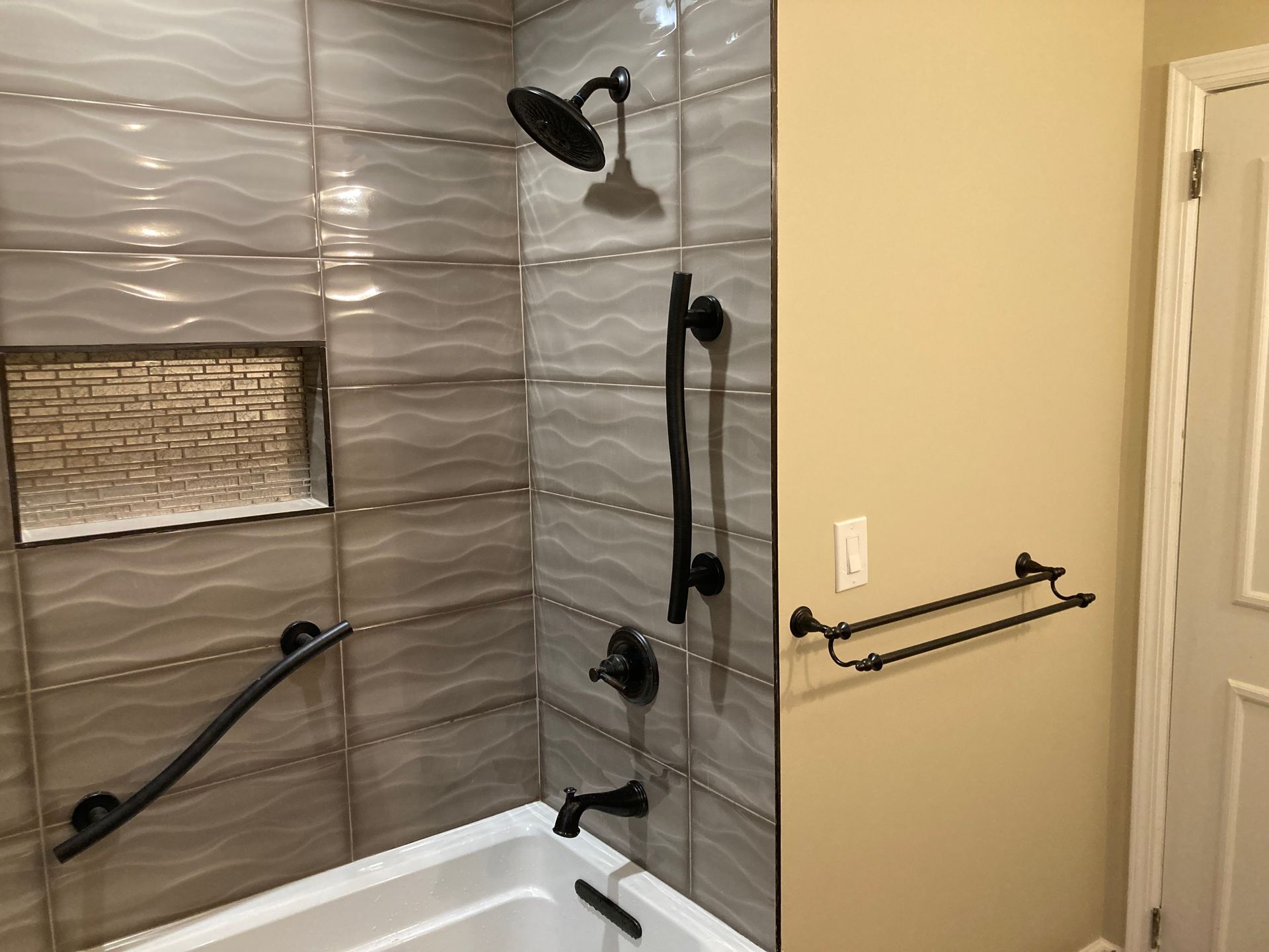 A bathroom with a bathtub , shower , and towel rack.