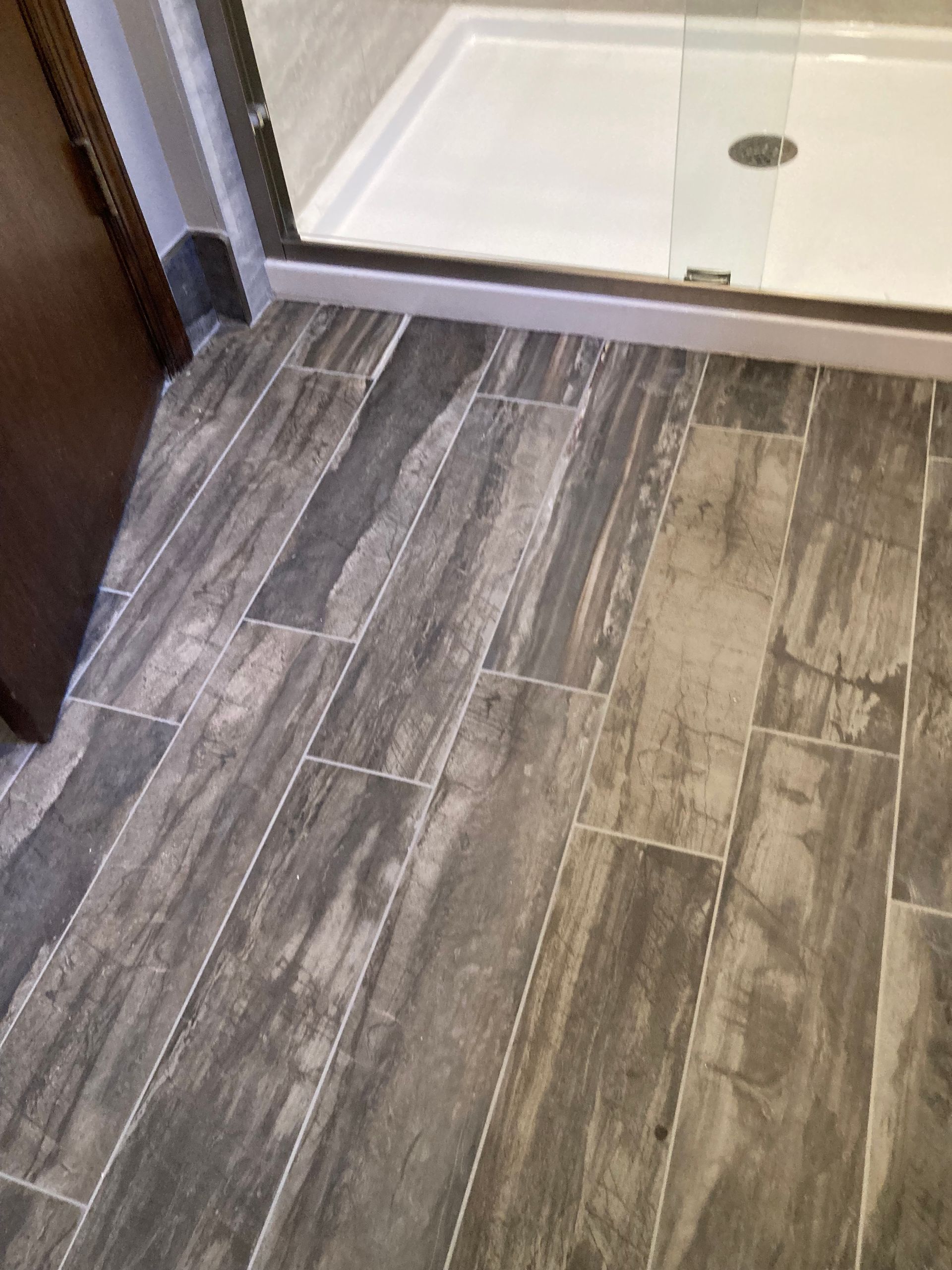 A bathroom with a walk in shower and a tiled floor.