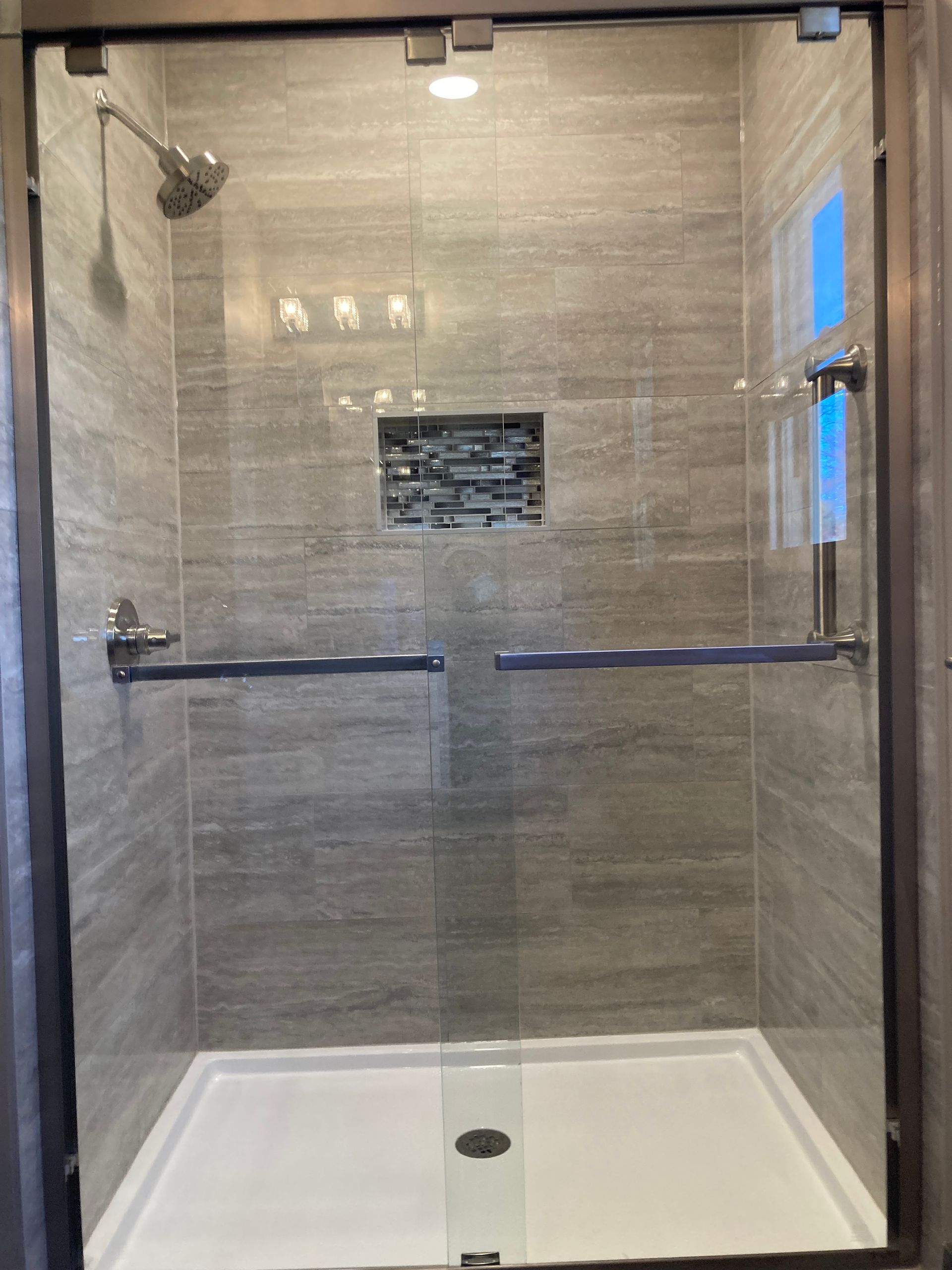A shower stall with a glass door and a shower head.
