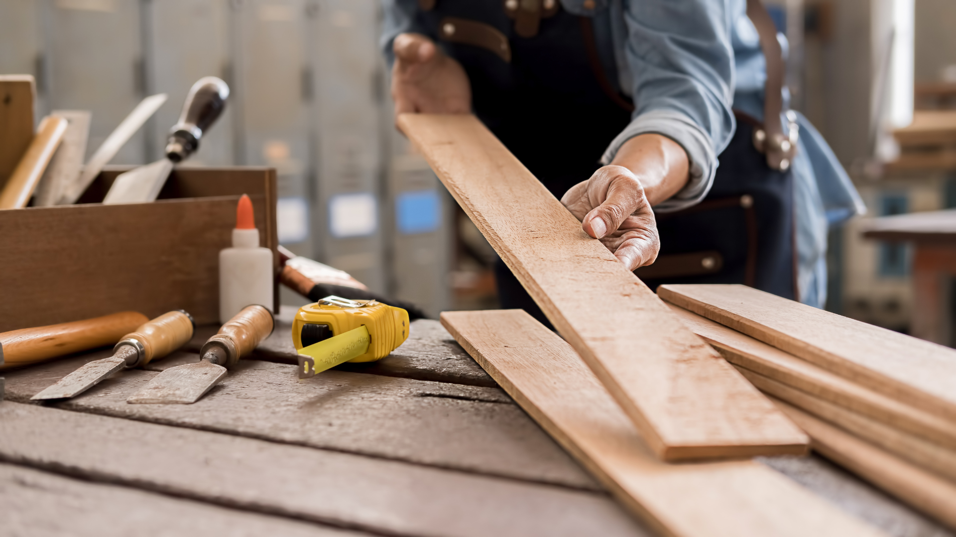 A person is measuring a piece of wood on a table.