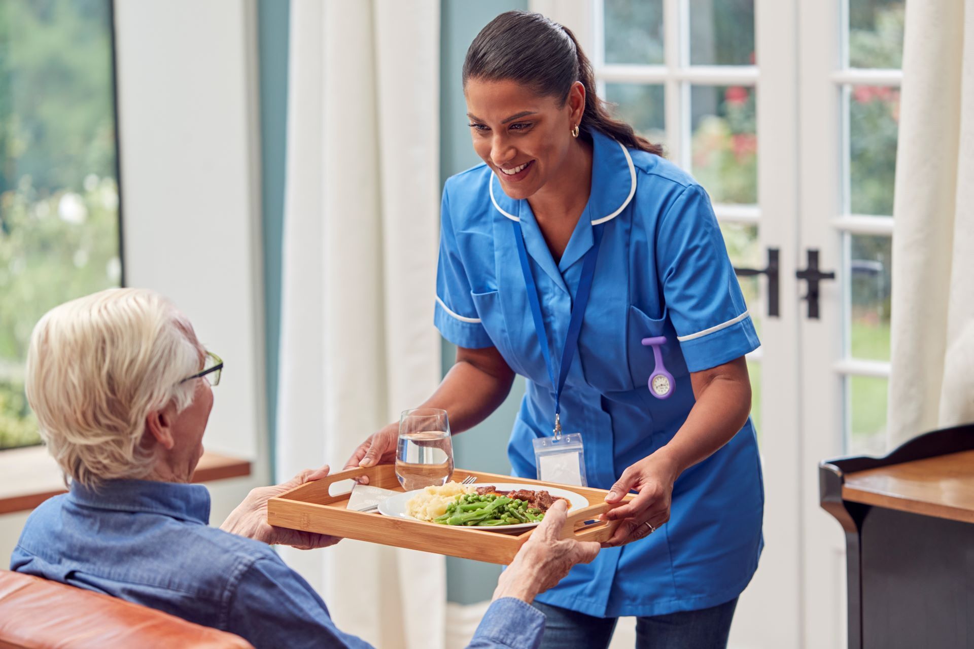 caregiver bringing elderly man food