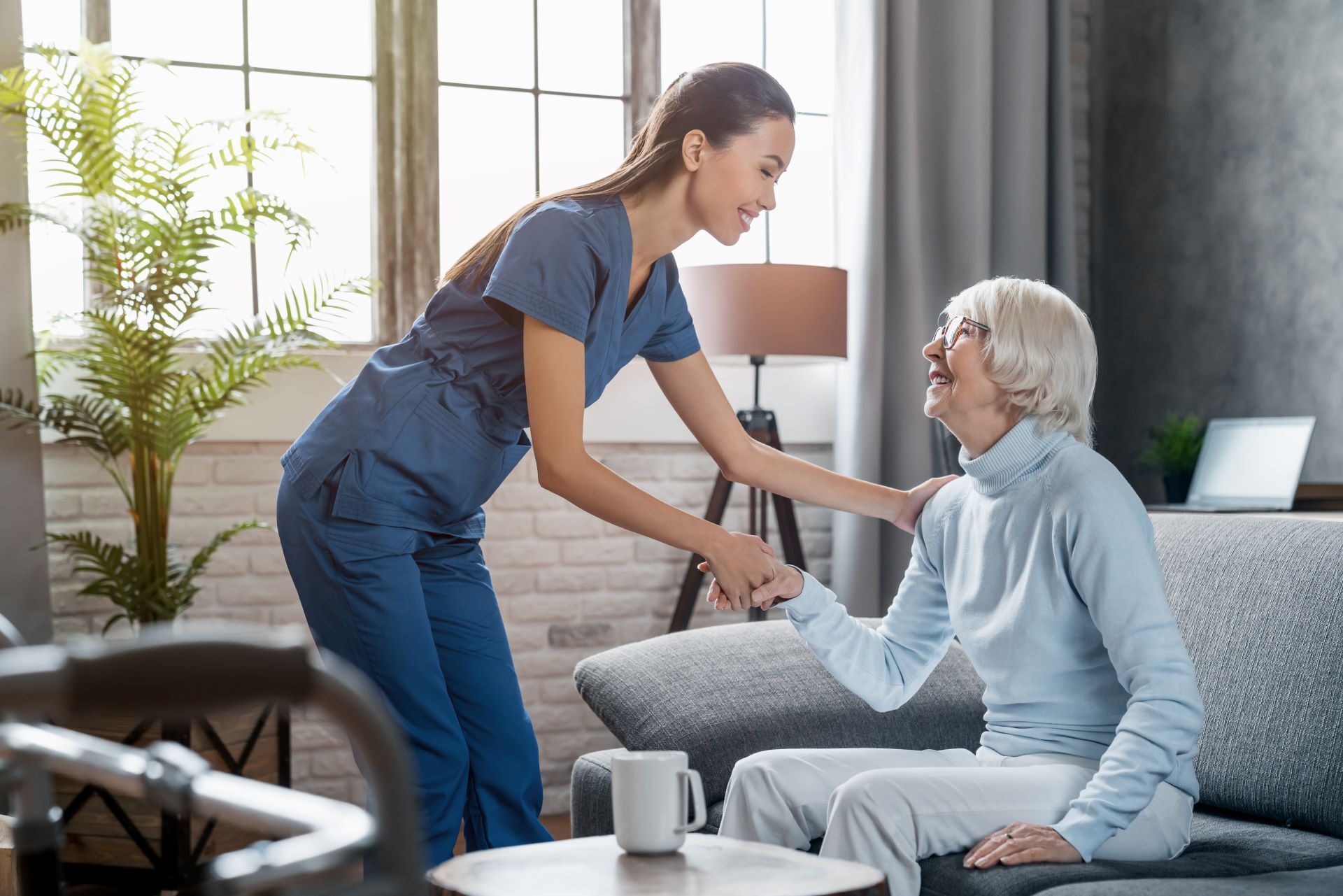 smiling caregiver shaking senior patient's hand