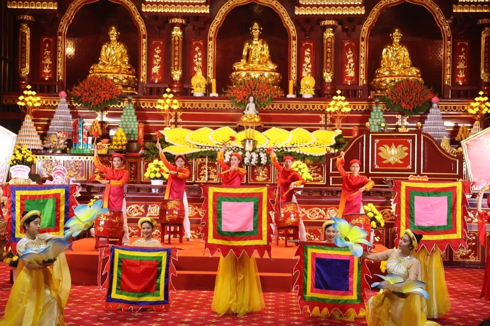 A vibrant traditional festival in Vietnam with performers dressed in colorful costumes, holding decorated square banners in a sacred temple setting.
