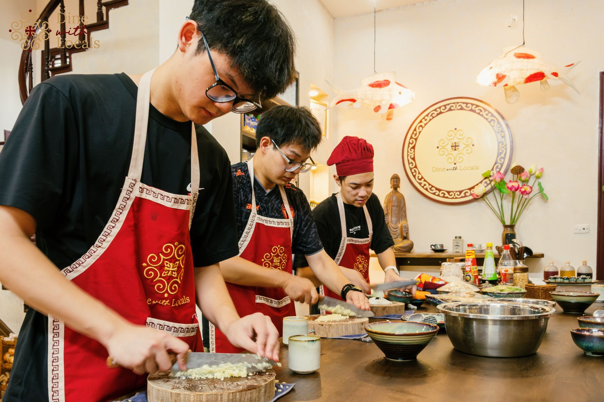 People in aprons chopping ingredients during a Vietnamese cooking class.