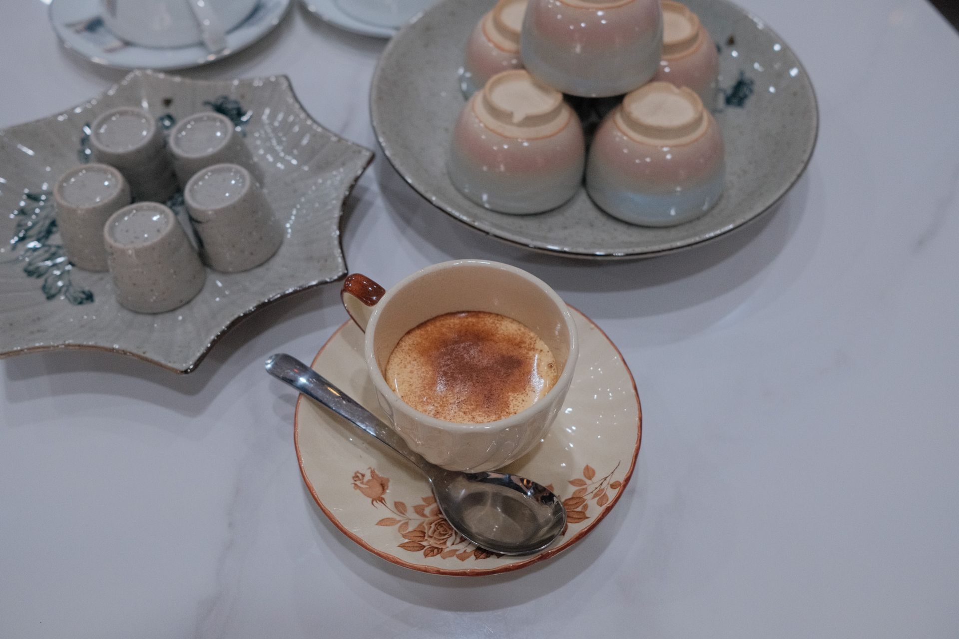A beautifully arranged Vietnamese coffee set, featuring ceramic cups and a classic drip filter.