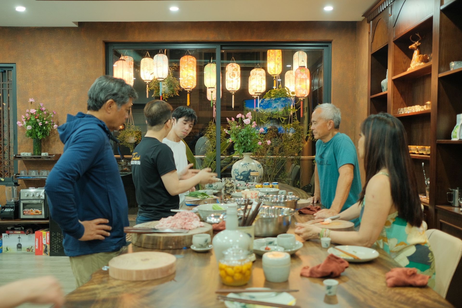 A group of people participating in a Vietnamese cooking class with a local chef, preparing traditional dishes together at Dine with Locals.