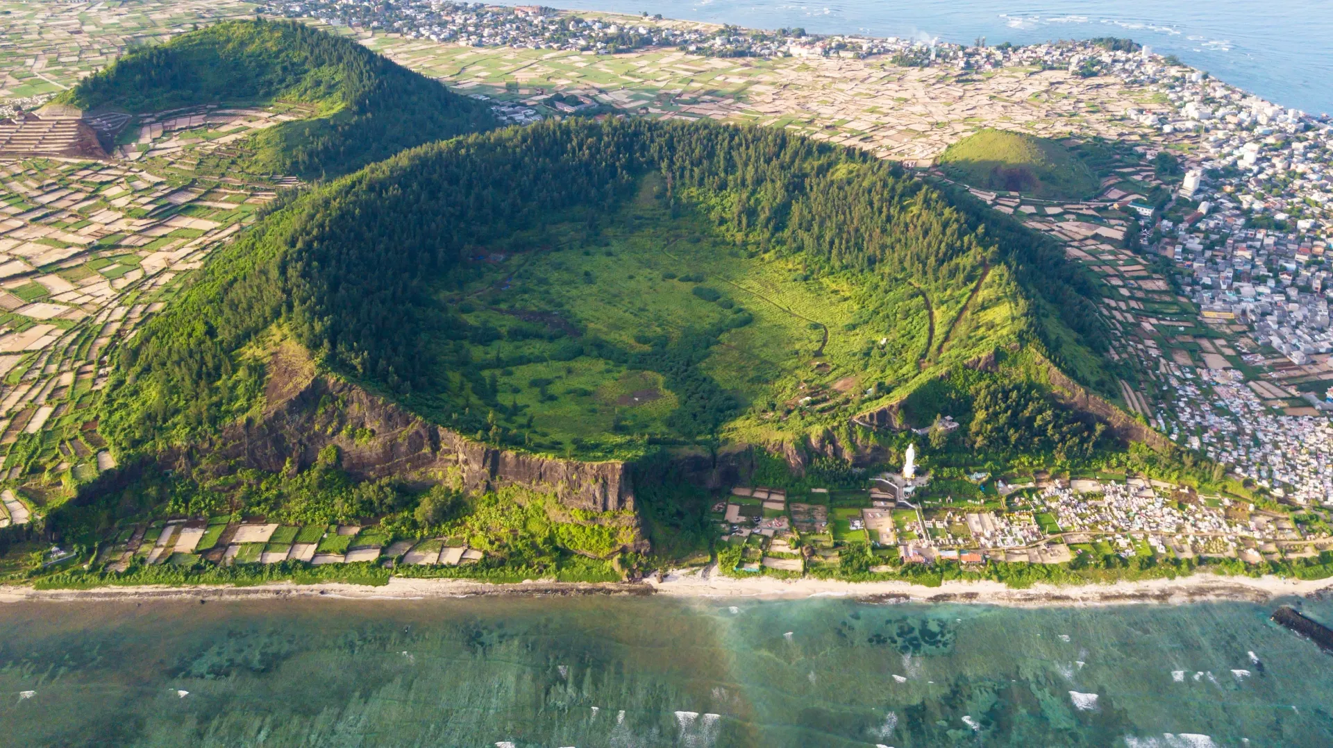 A dramatic view of Ly Son volcanic island, featuring a distinctive mouth-shaped crater formation.
