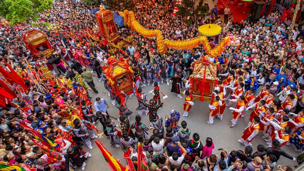 A bird’s-eye view of Lim Festival in Bac Ninh, Vietnam, showing a crowded street with dragon dances, palanquins, and performers in traditional costumes.