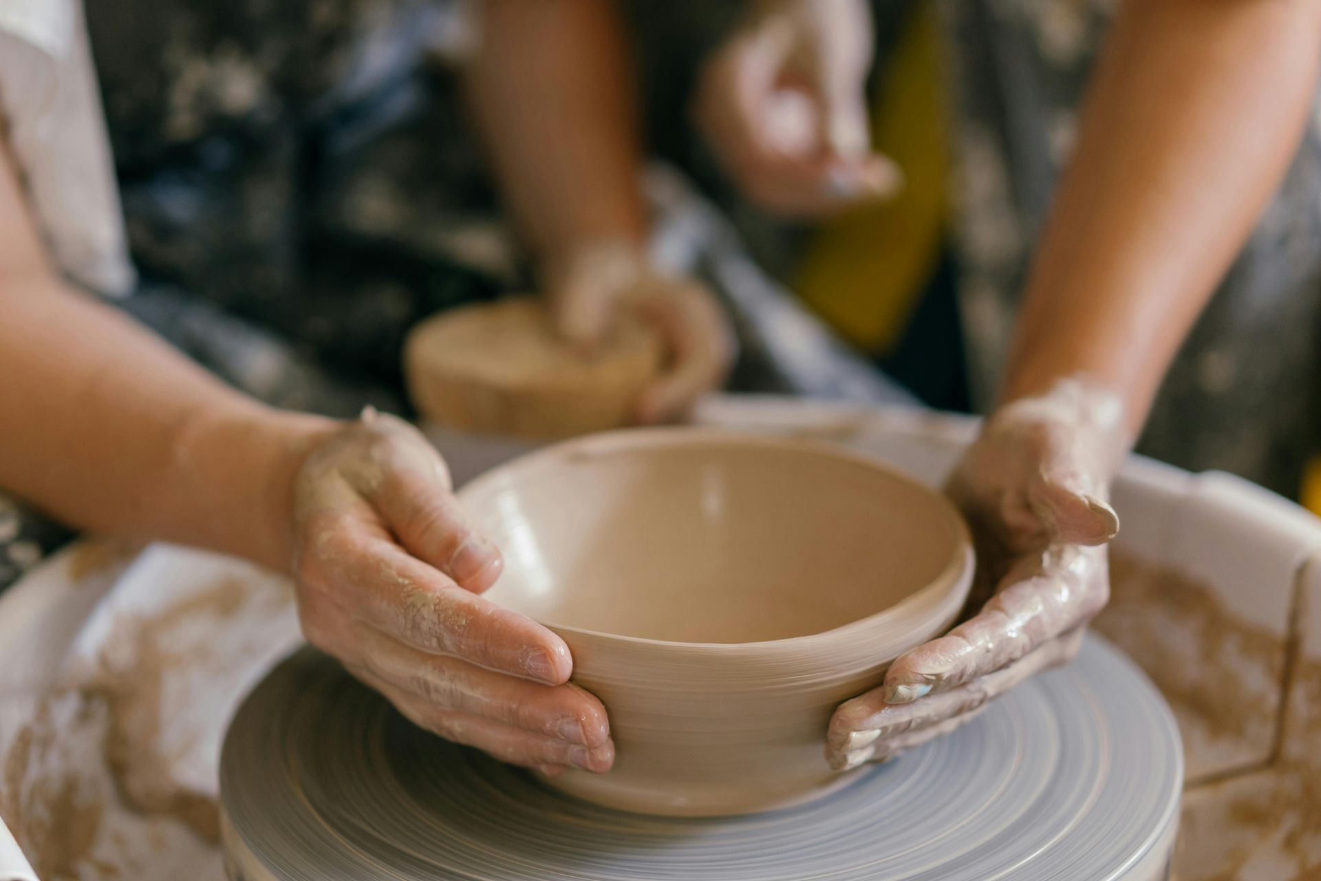 An artisan shaping clay on a pottery wheel in the Bat Trang ceramic village.