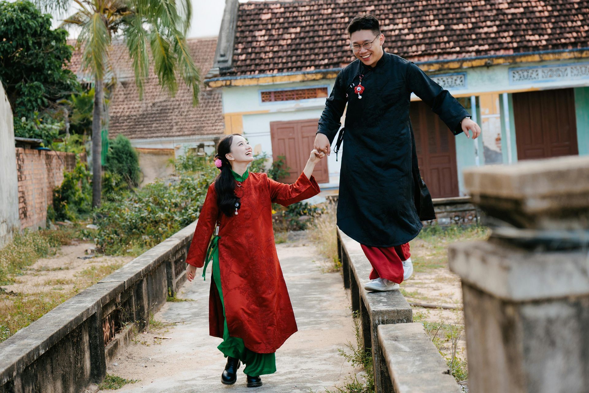 a couple wearing traditional ao dai and play outdoor