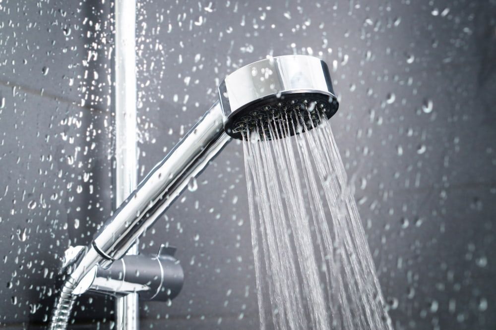 A Close up Of a Shower Head with Water Coming out Of It — Custys Plumbing Services in Trinity Park, QLD