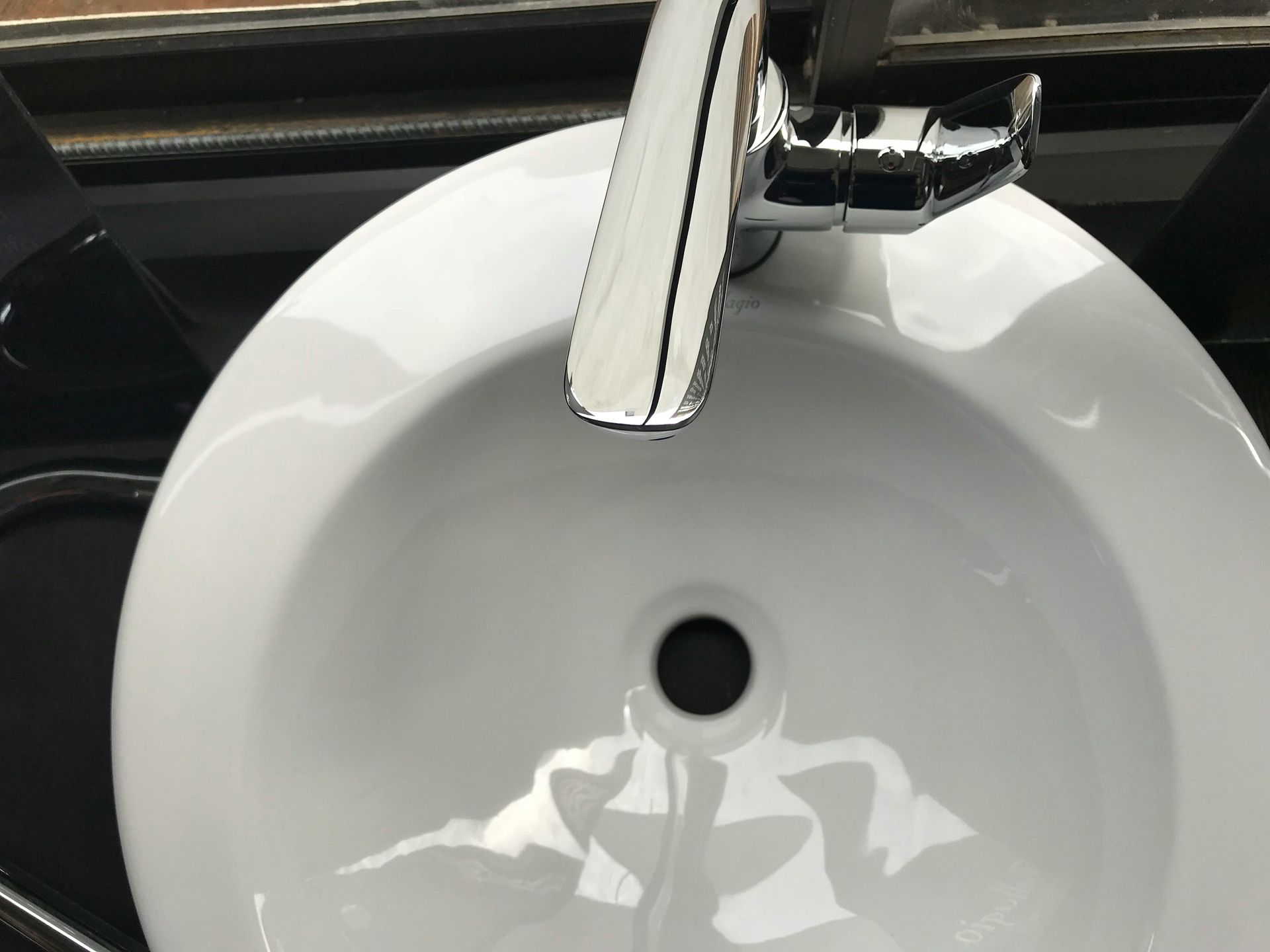 White sink with chrome faucet overhead.