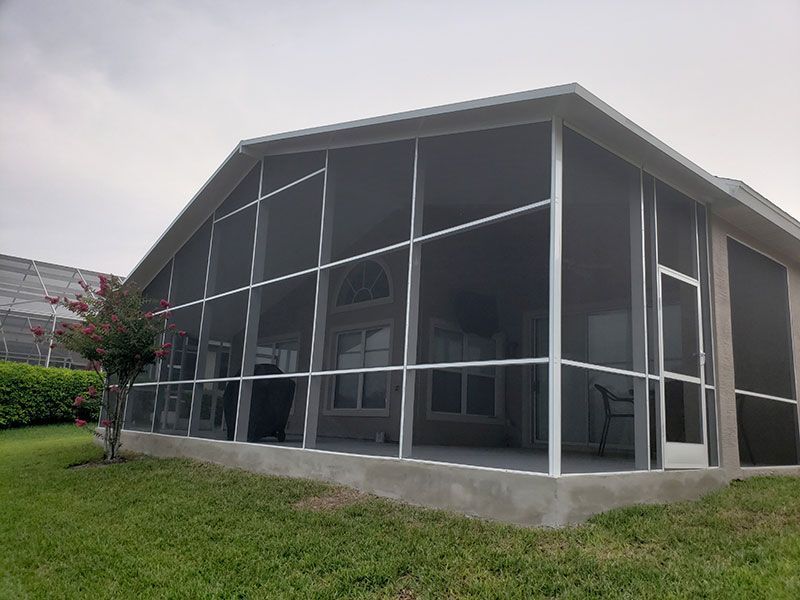 Modern glass-walled building with a sloped roof on a grassy lawn