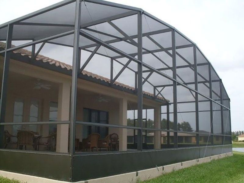 Large screened-in porch with a gray metal frame and roof attached to a house