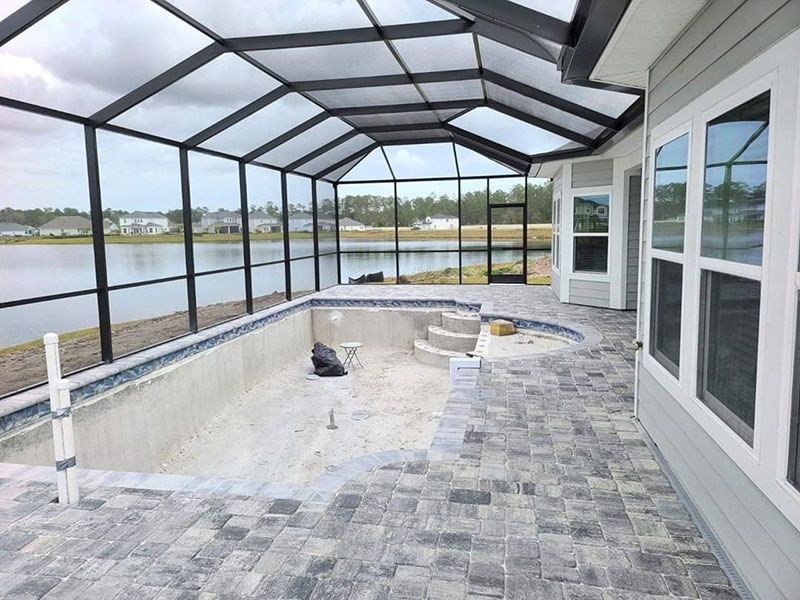 Screened-in pool deck with hot tub area overlooking the water