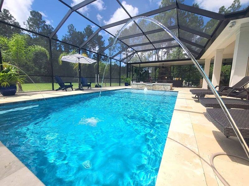 Sunny backyard pool with screened enclosure, lounge chairs, and blue water