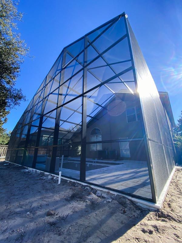 Glass greenhouse with blue frame in a sunny outdoor setting