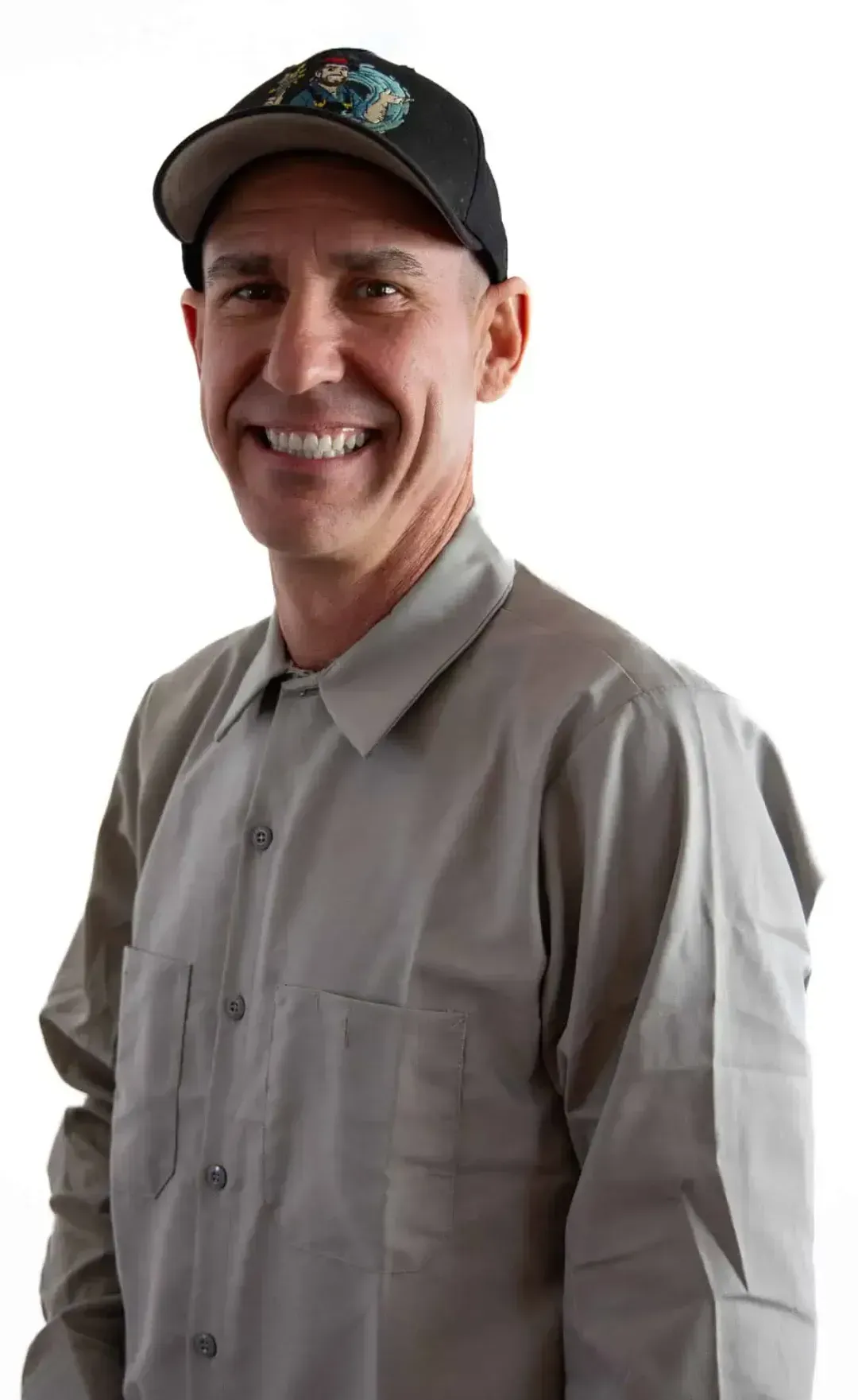 Smiling man in a gray shirt and black cap against a white background