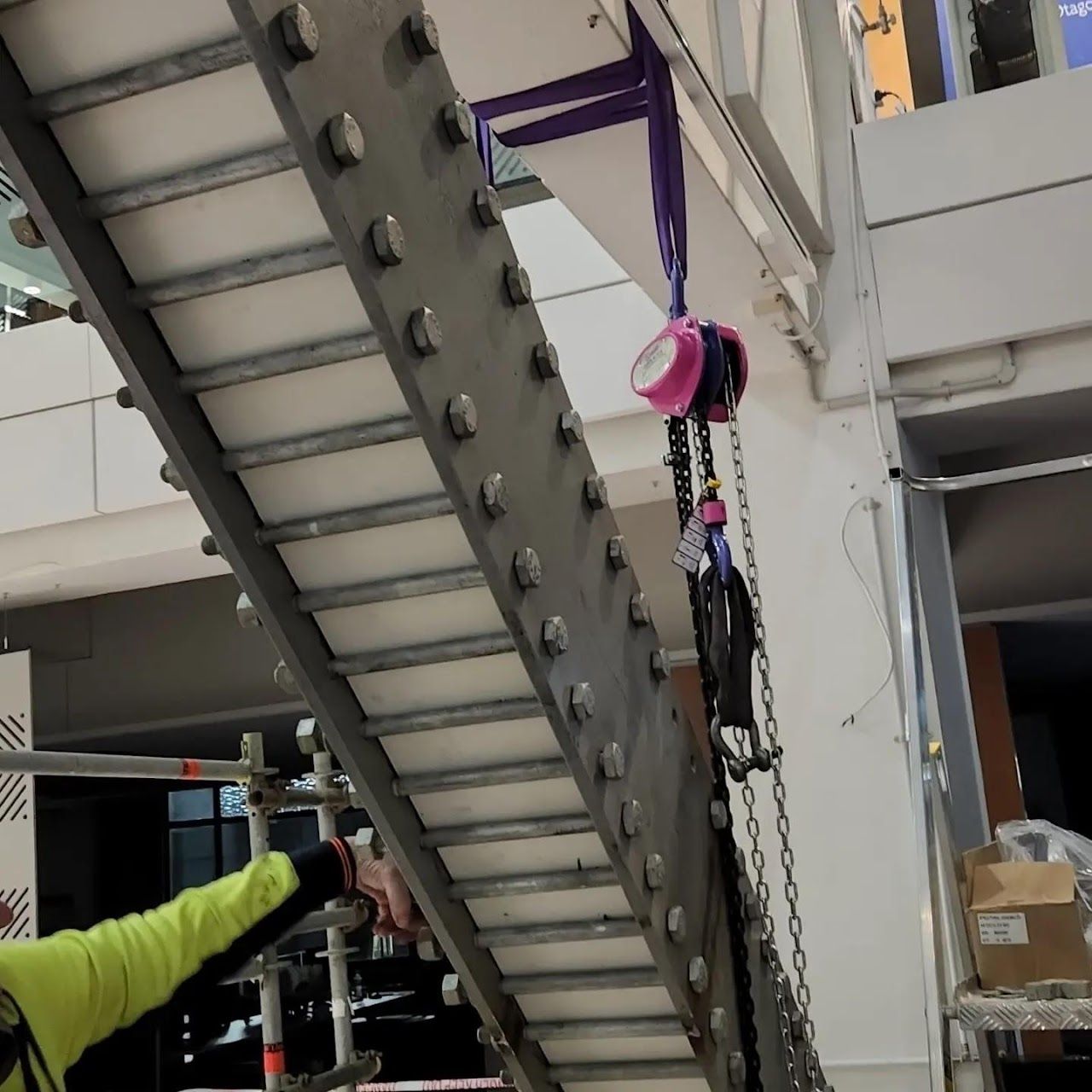 A man in a yellow shirt is working on a staircase.