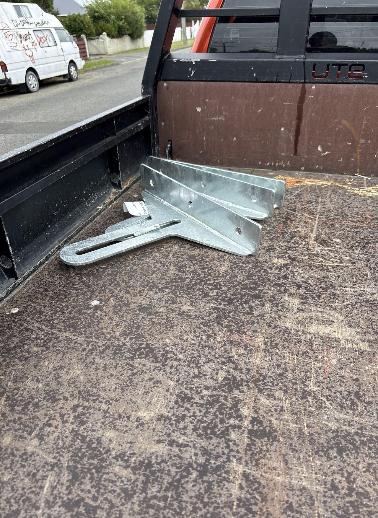 A piece of metal is laying on the ground in the back of a truck.
