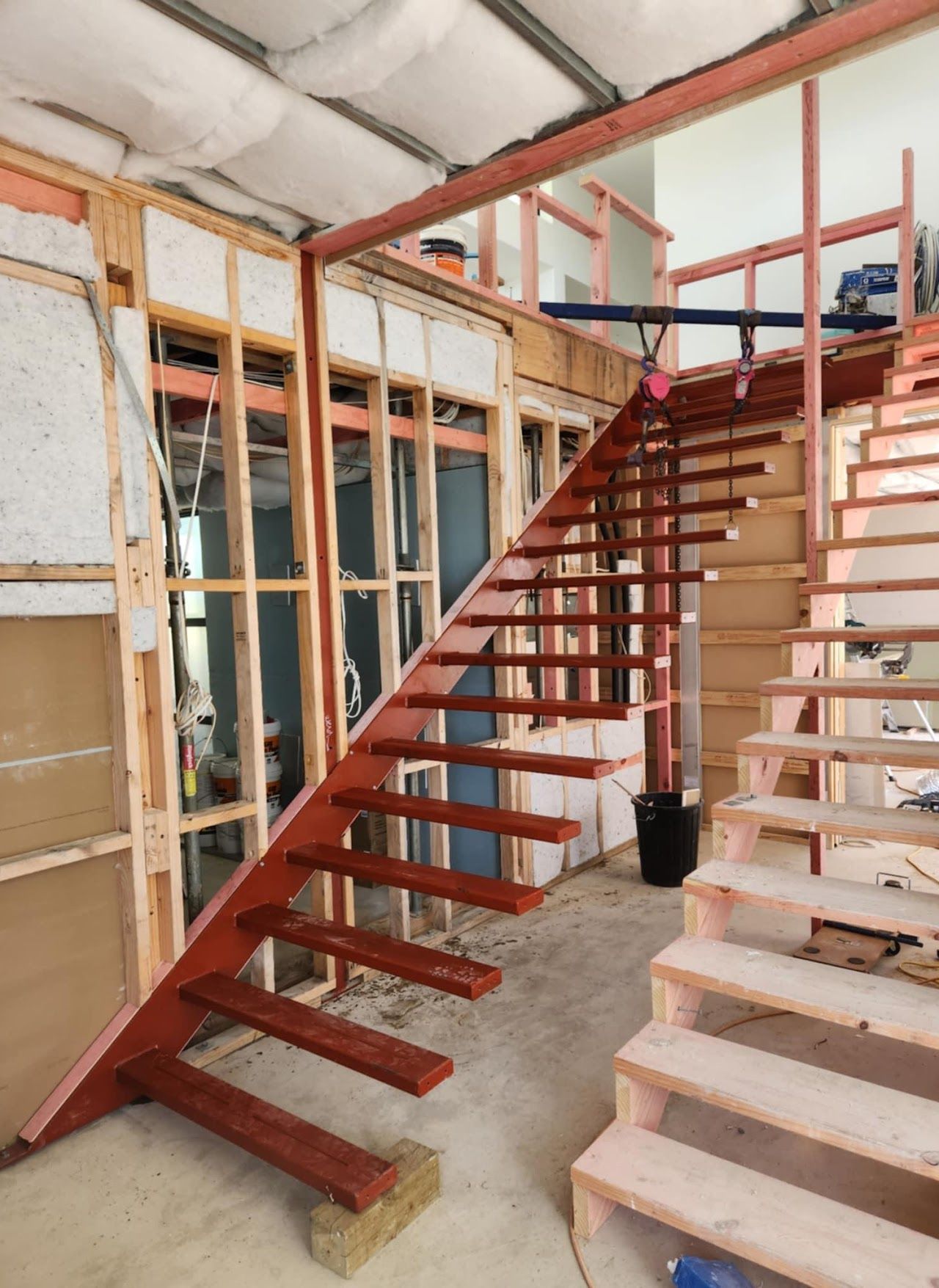 A wooden staircase is being built in a room.