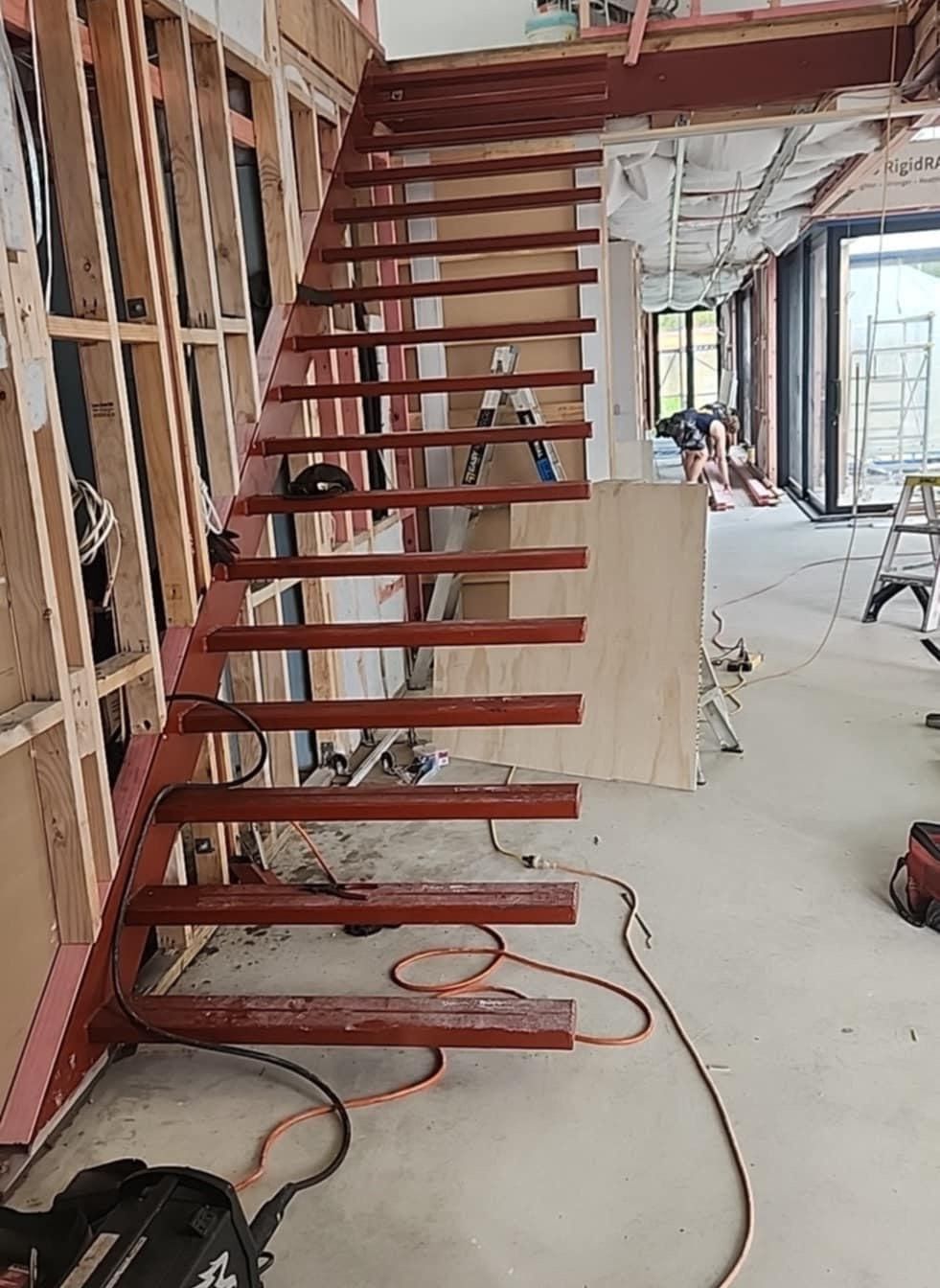 A wooden staircase is being built in a building.