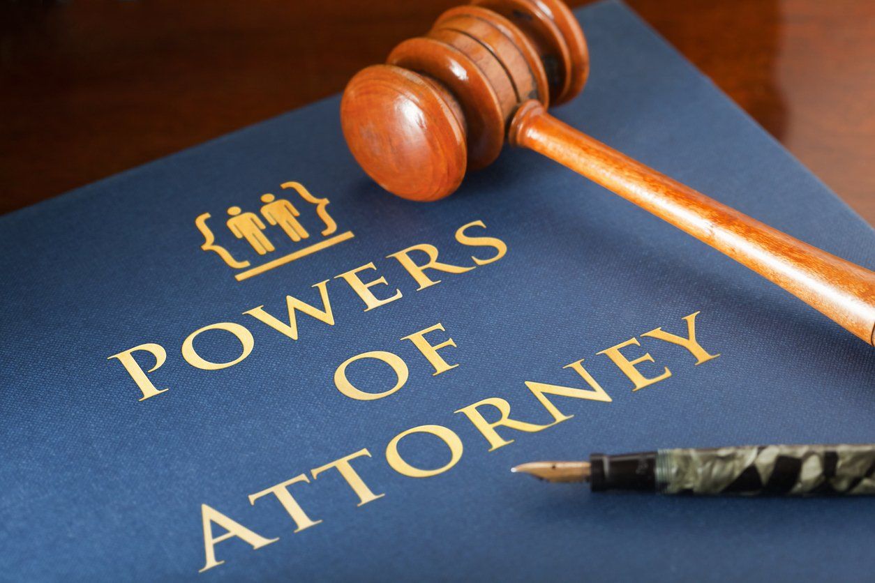 A wooden gavel and fountain pen rest on a dark blue document titled