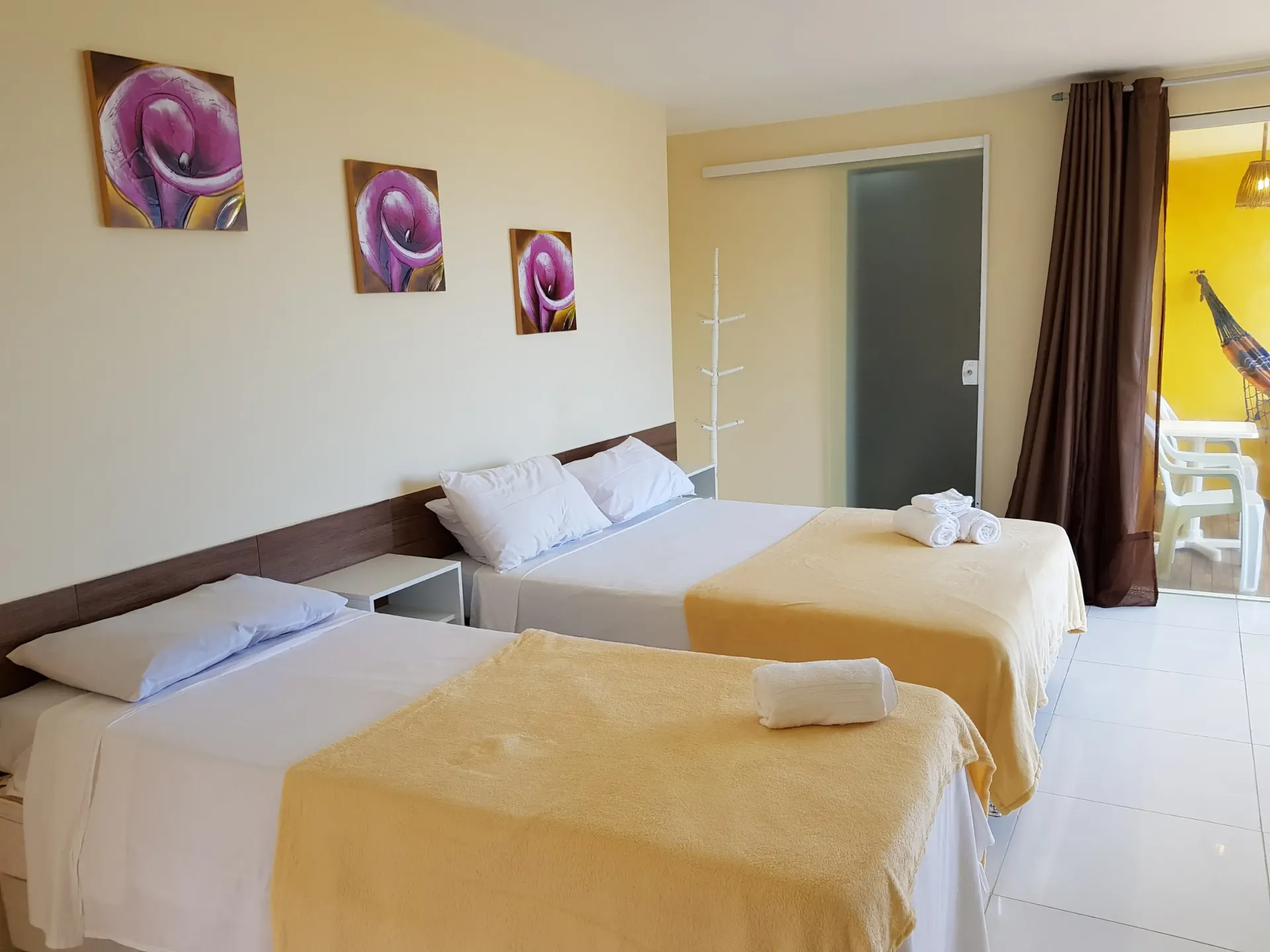 Um quarto de hotel com duas camas e uma mesa.-Pousada Águas de Piruí