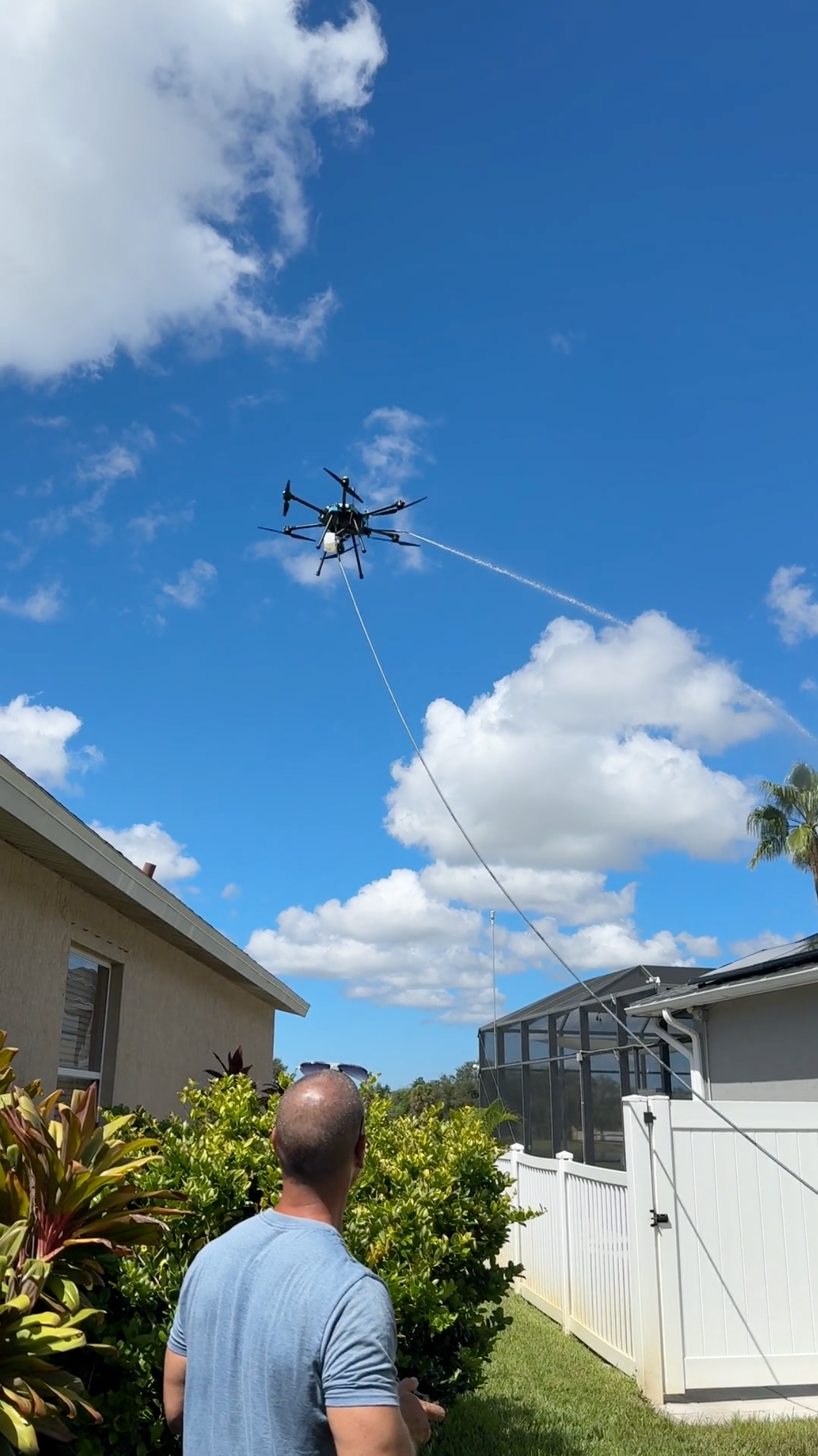 Drone on a terracotta tile roof beside solar panels in a sunny suburban neighborhood