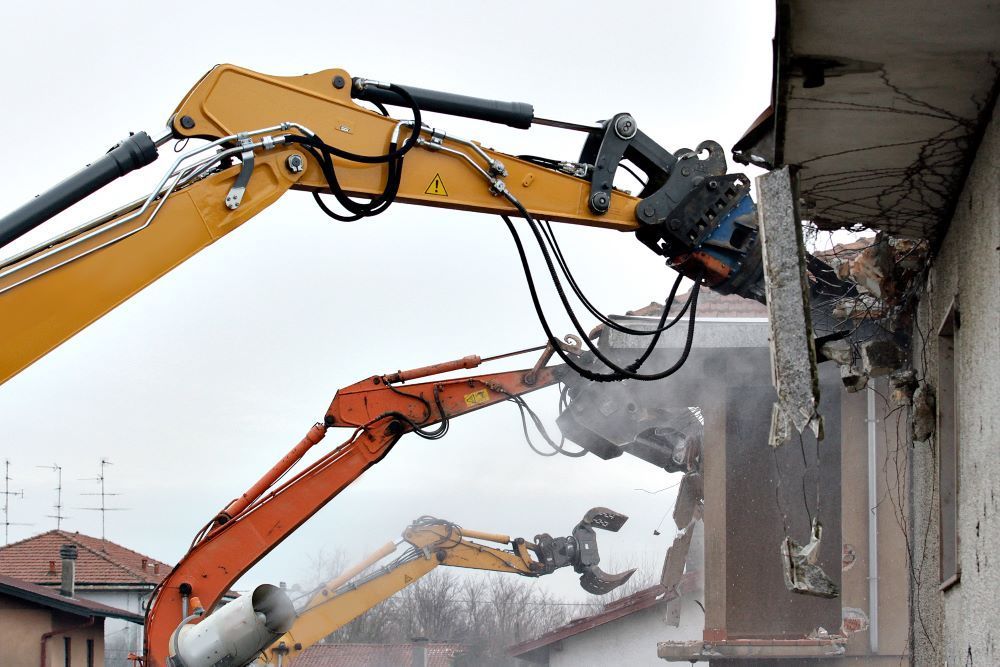 A Group Of Excavators Are Demolishing A Building — Northern Demolition and Civils in Innisfail, QLD