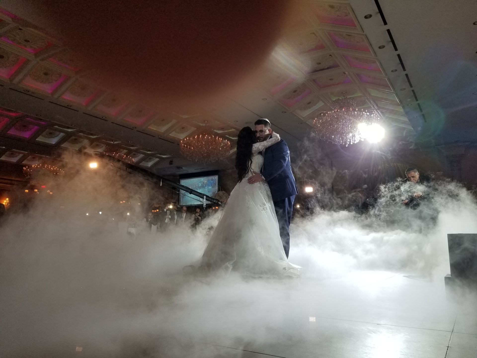 Wedding DJ LI, Couple dancing on a stage surrounded by fog, celebrating their wedding.
