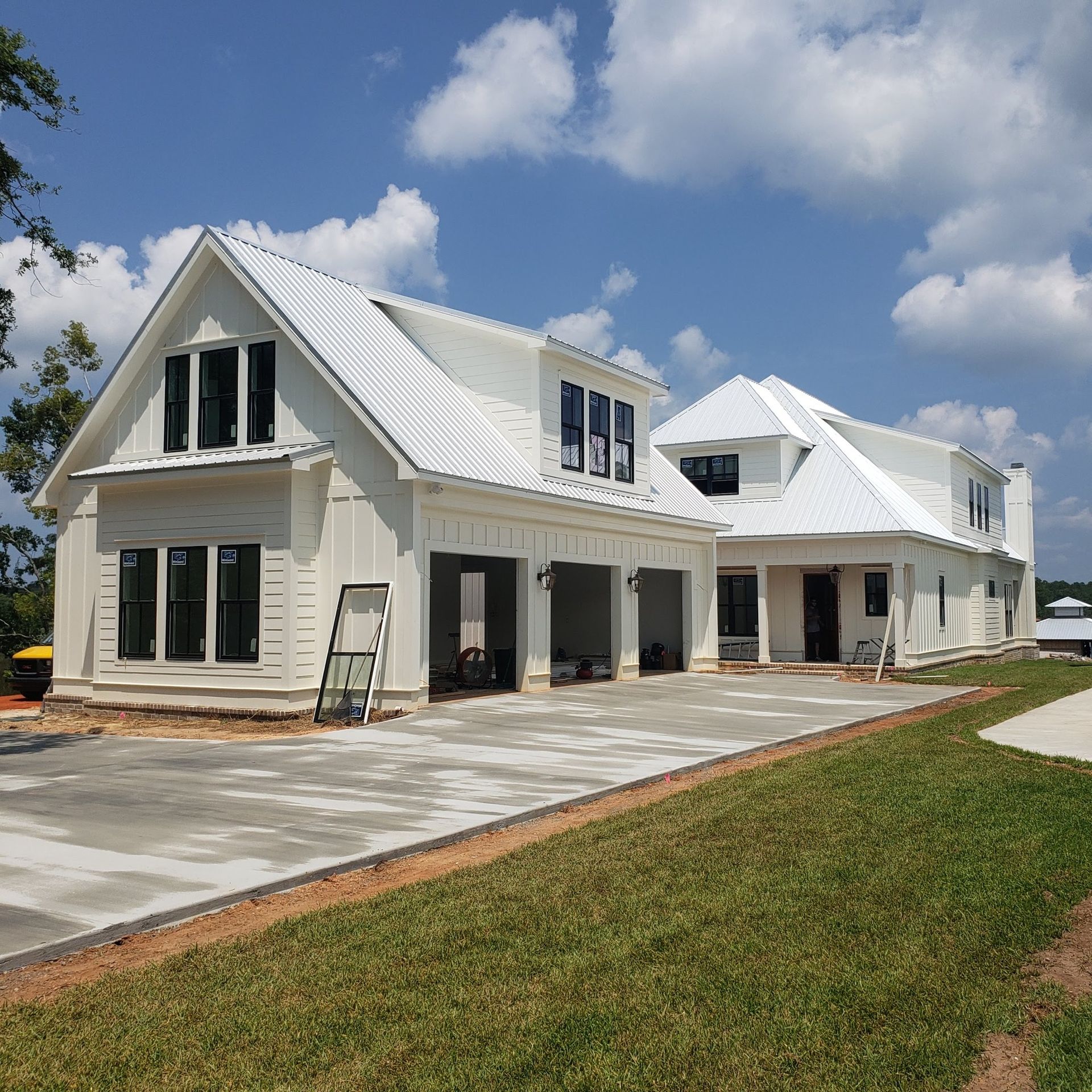 A large white house with a concrete driveway in front of it