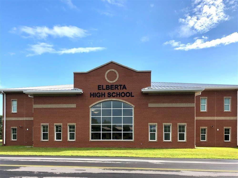 Red brick Elberta High School building with a large central window and a blue sky above.