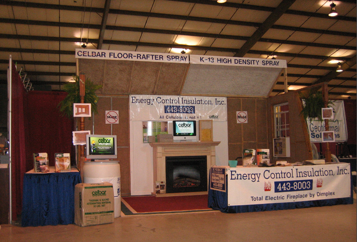 Energy Control Insulation, Inc. trade show booth with a fireplace display and company branding at an indoor venue.