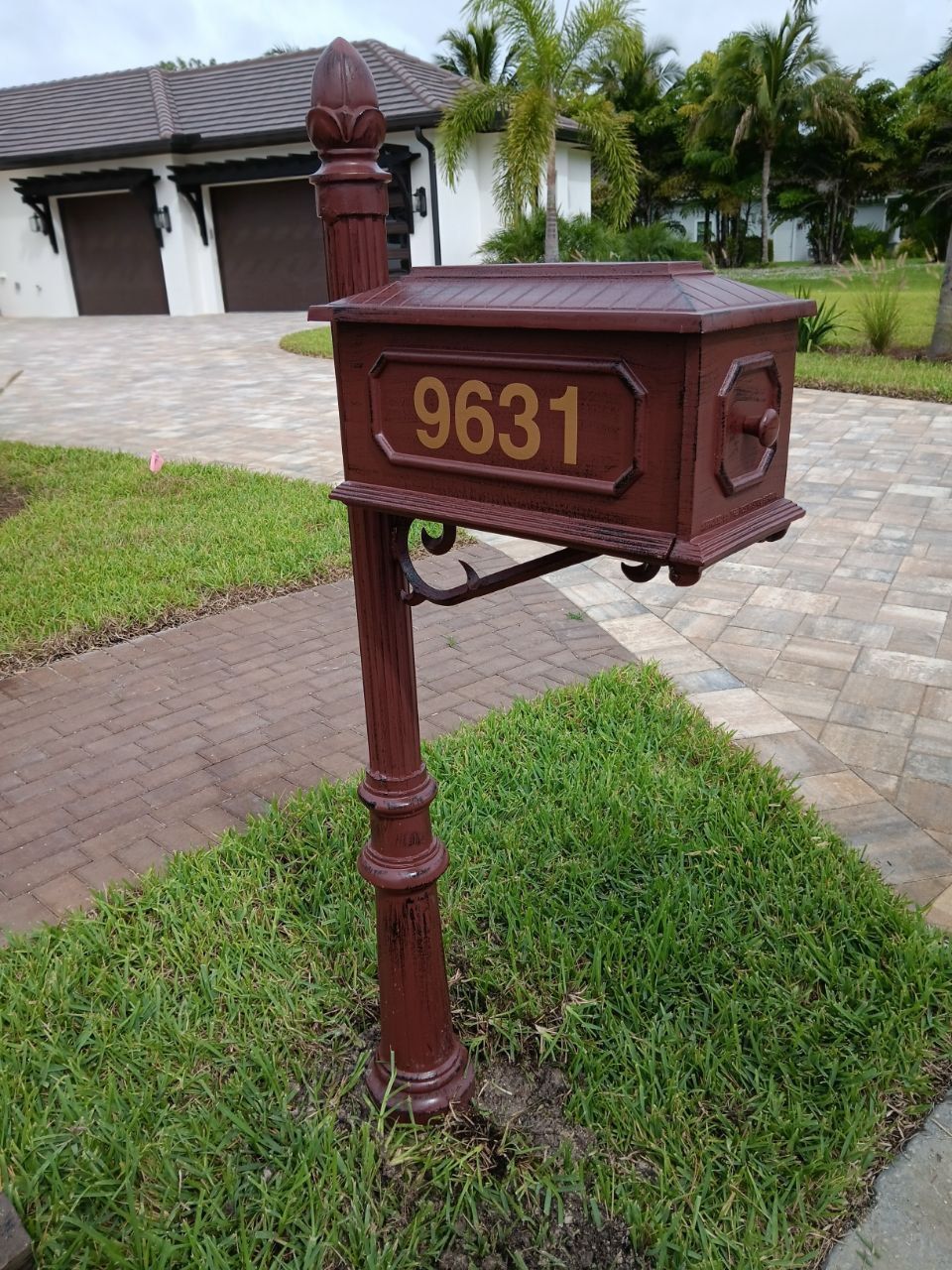 A mailbox with the address 9631 is in front of a house.