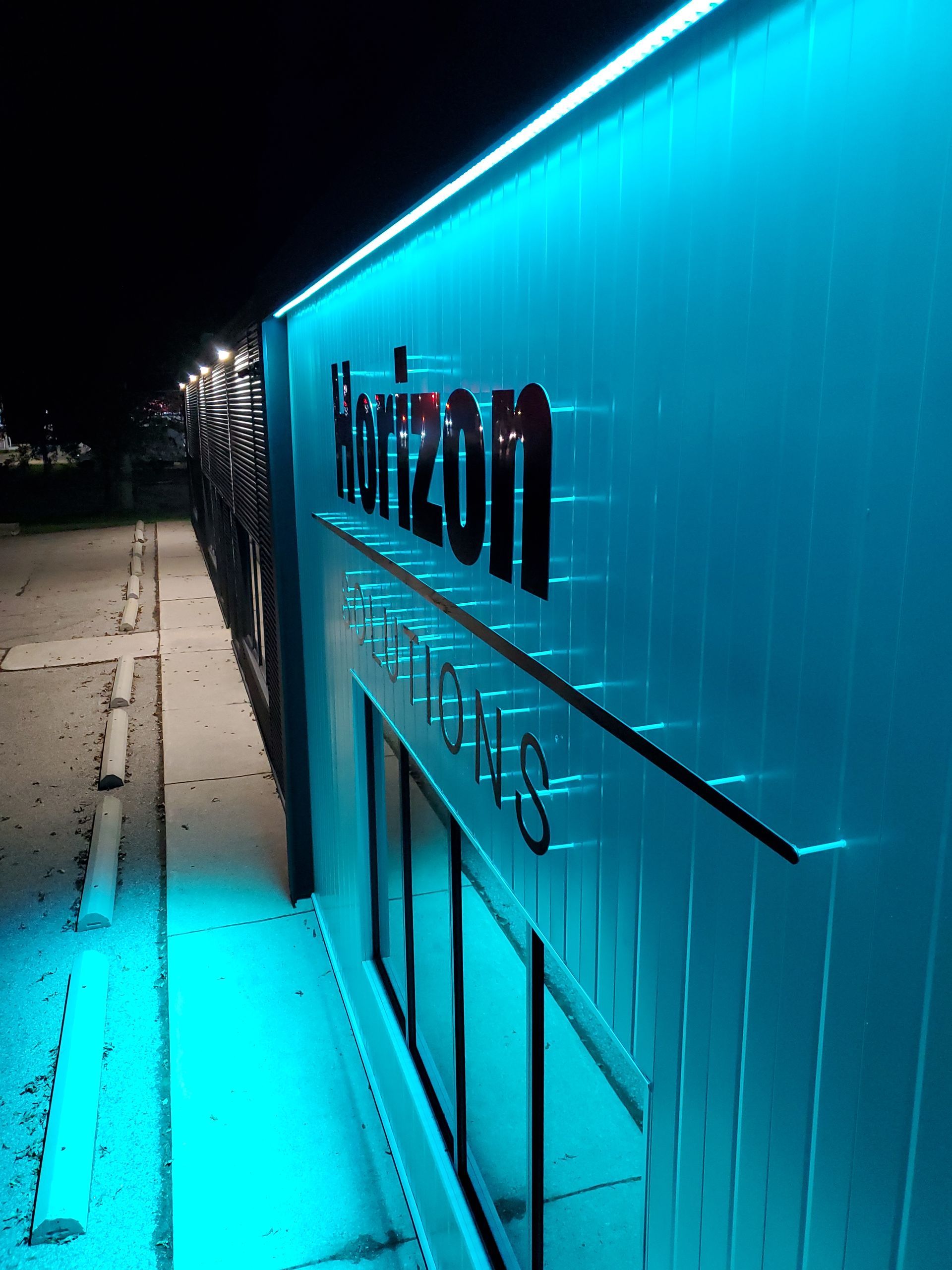Horizon Solutions office building sign lit up at night.