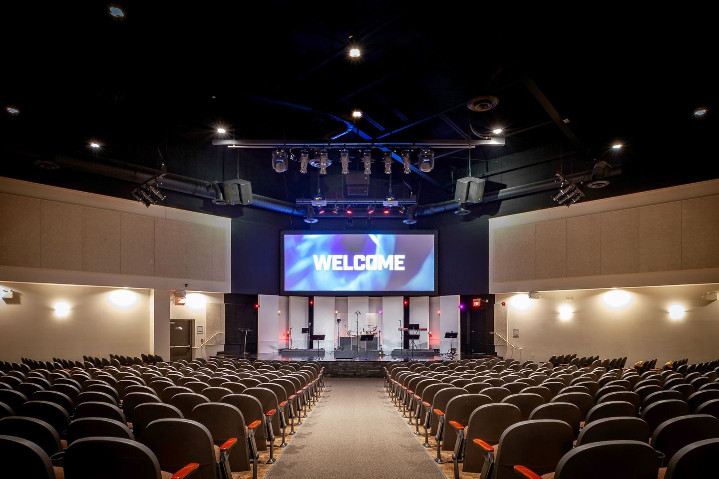 A large auditorium with a welcome sign on the screen